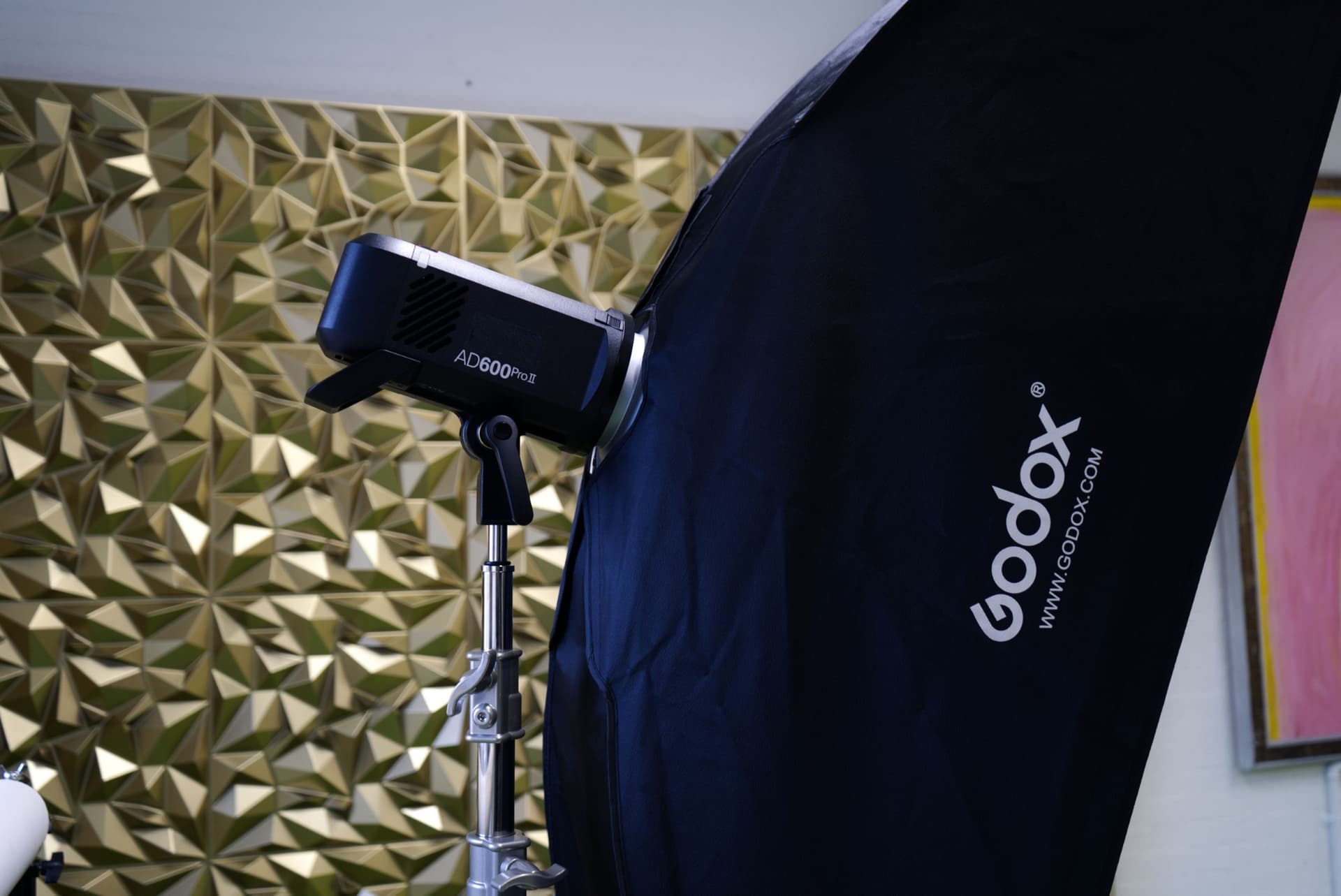 Godox AD600 Pro II strobe with a softbox against a gold faceted wall